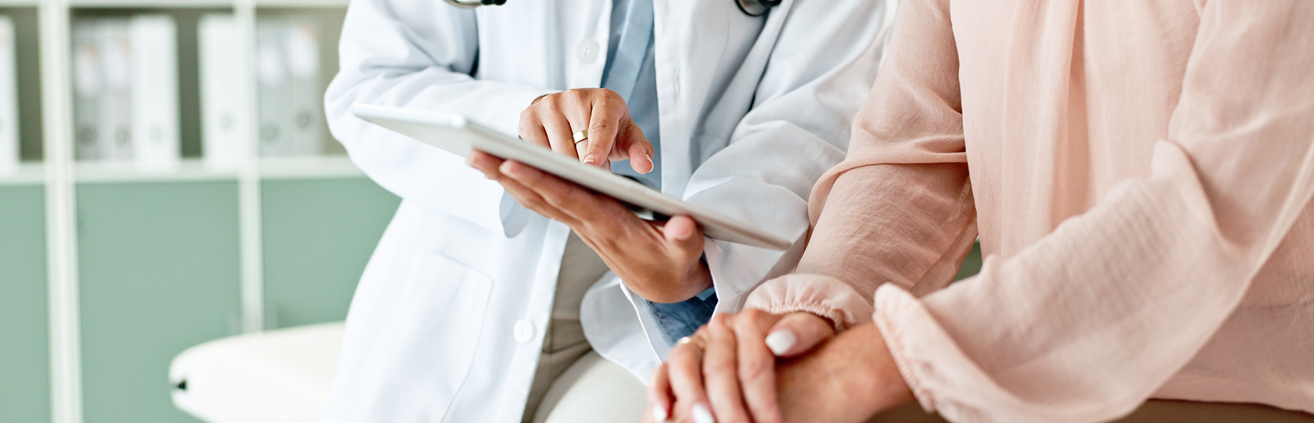 A well-lit reception area with a desk, computer monitor, and potted plant.